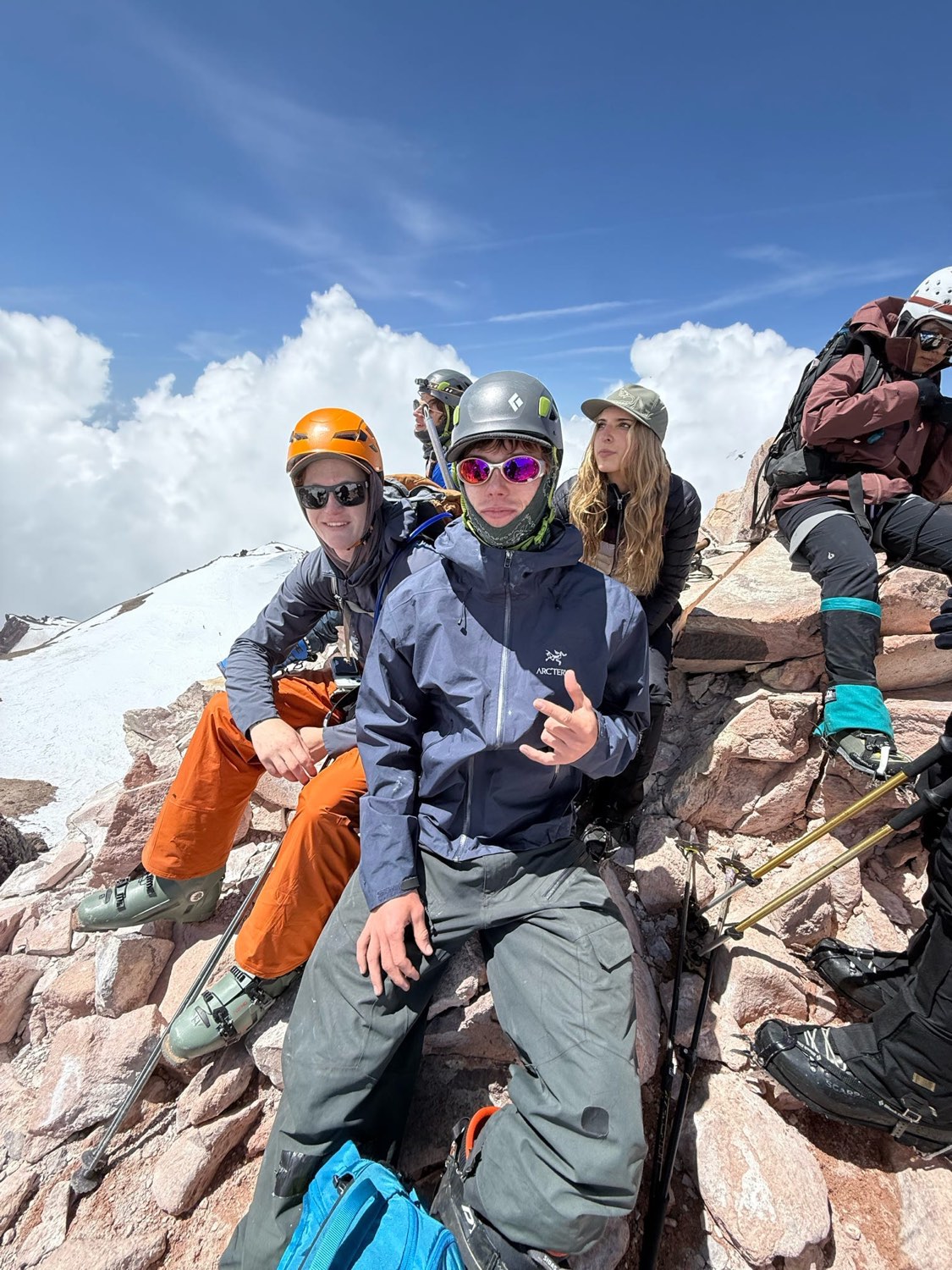 Brothers in mountaineering gear on a rocky summit ridge